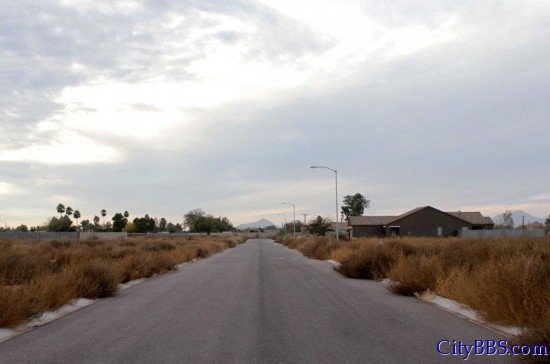 美国亚利桑那州库利奇一个未完工的建筑项目，公路两旁野草丛生