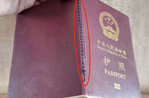 护照中缝装订处有明显用黑线缝补的痕迹