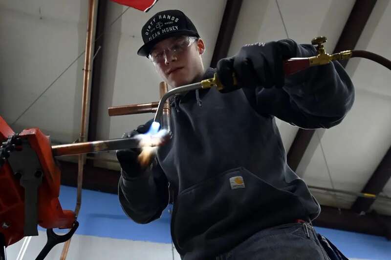 20岁的Williams在学徒培训课程中焊接铜管