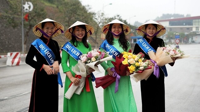 越方工作人员在越南谅山省的友谊国际口岸手捧鲜花欢迎中国游客